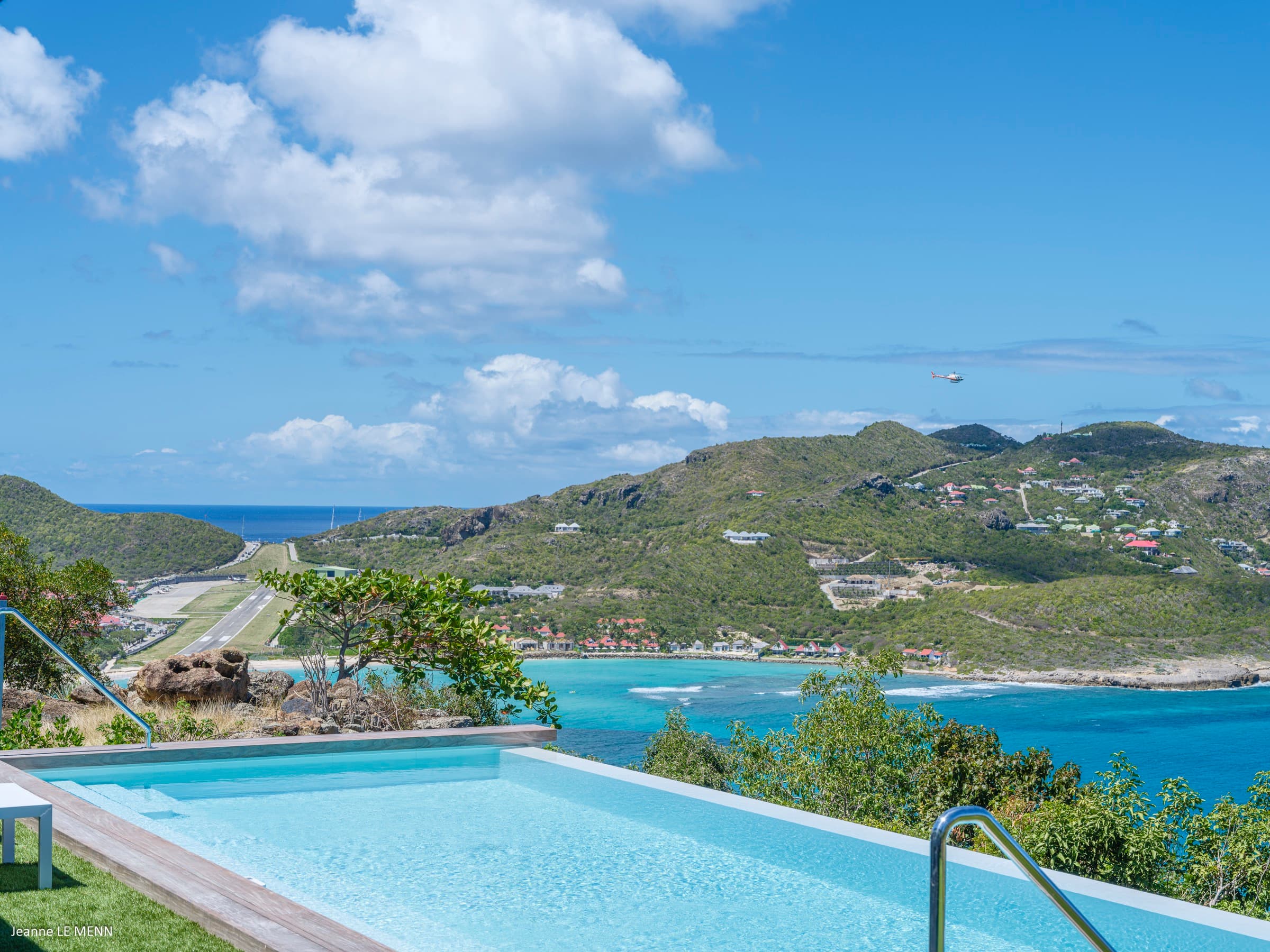 Pool and garden with daytime ocean views